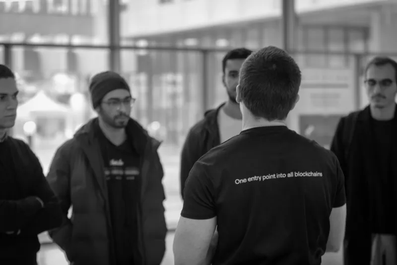 Paul Dupont, in a ZetaChain T-shirt, talking with a small group at Télécom Paris
